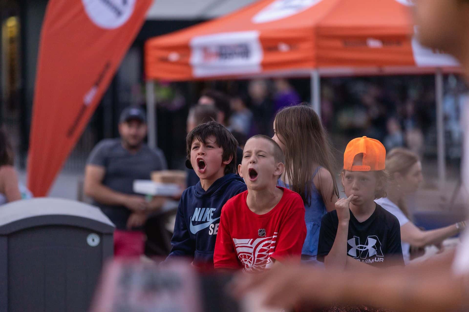 3 young boys getting in the rock & roll spirit, belting along to the live band on the Subaru Stage.