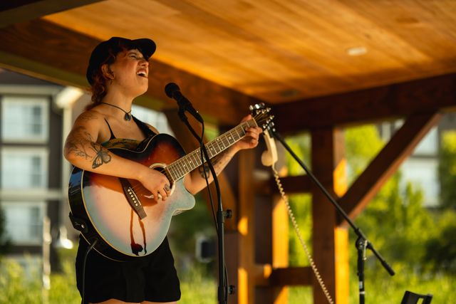 Local singer/songwriter, Miranda Journey, performing an acoustic set on the Floating Stage during golden hour at Blue Mountain Village.